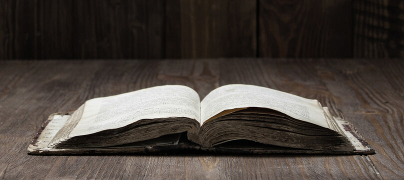 Image of an old  Holy Bible on wooden background on a wooden background in a dark space