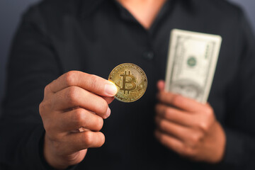 Investor guy showing a bitcoin gold coin and US banknotes while standing in the studio. Close-up photo. Space for text. Virtual cryptocurrency and future money concept