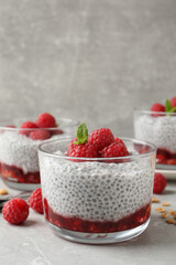 Delicious chia pudding with raspberries and mint on light marble table, space for text