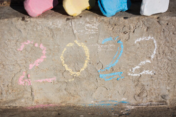 inscription 2022 in various colors on a concrete surface and chalk