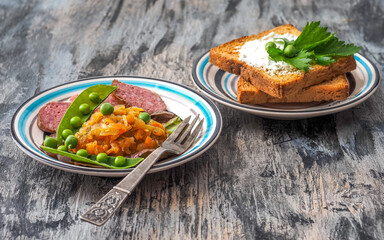Quick breakfast of vegetables and sausages, two fried sandwiches