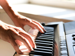 Obraz premium Pianist hand playing digital piano. Close-up. Music concept, learning to play the piano. Space for text. Vectical