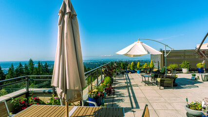 Rooftop patio at a UniverCity Highlands, BC,  residence with umbrellas and extensive views across valley.