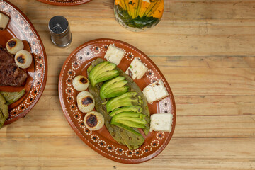 Mexican food. order of avocado with nopal and onion served in an earthenware plate on a wooden table
