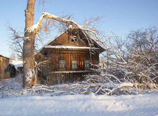 Winter in the Russian village. The tree fell on the house.
