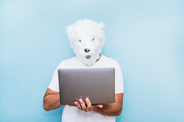 Man in a polar bear mask using a laptop.