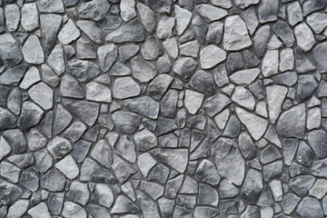 Black and white background of a stone wall.The walls are made by hand from concrete and stone, as the decor of a modern building.Background of an ancient stone wall.