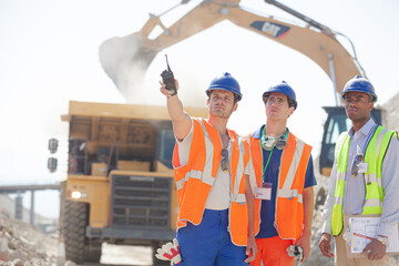 Business people and workers talking in quarry