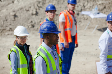 Workers talking with machinery in quarry