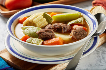 Mole de olla, red beef broth with meat, carrot, corn, pumpkin, potato, traditional Mexican dish