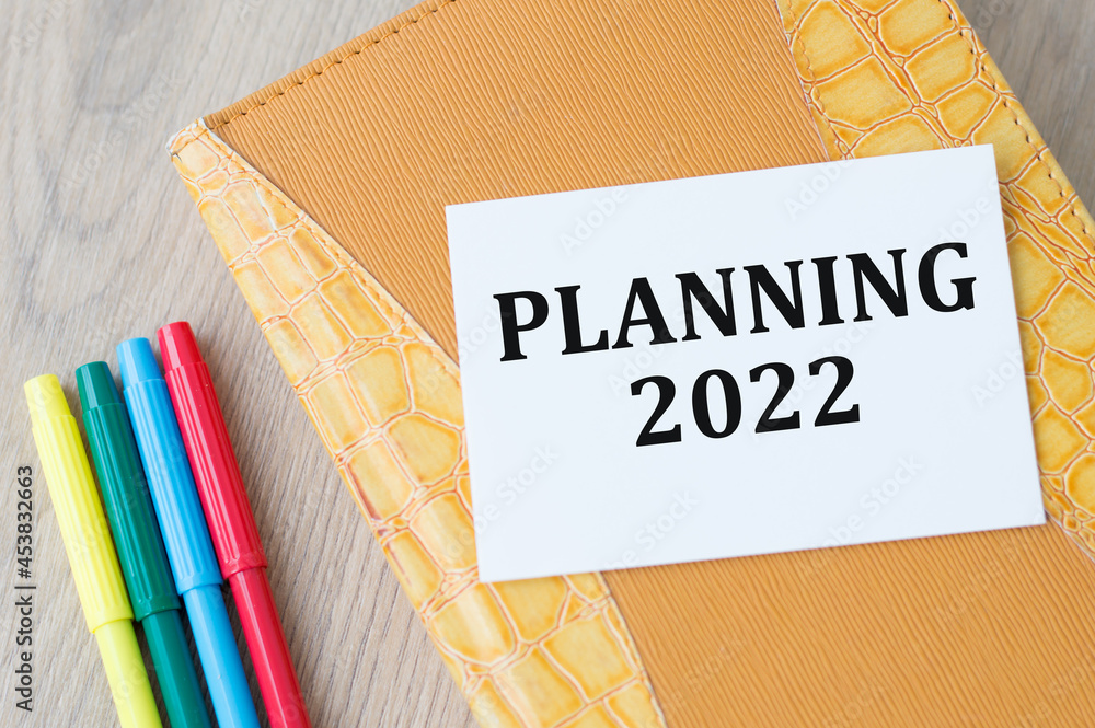 Poster planning 2022 text on white paper on the background of a notebook on the table