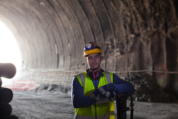 Worker holding sledgehammer in tunnel