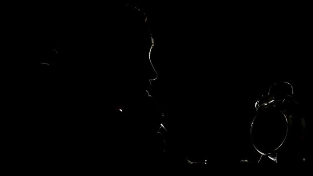 Man in the dark looking time passing on clock, insomnia