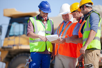 Worker standing by machinery on site