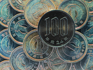 100 yen lies on a pyramid of Japanese 1 yen coins. View from above. Inverted colors. Dark catchy illustration. Money seems to be covered with a patina. News about the economy and finance of Japan