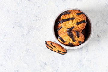 orange cookies with black stripes in bowl and fir tree branches. Christmas dessert. Concept for children new year