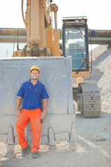 Worker walking by machinery on site