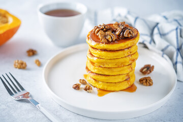 Pumpkin pancakes with walnuts and caramel sauce in a plate