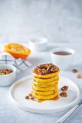 Pumpkin pancakes with walnuts and caramel sauce in a plate