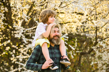 He makes him fly. father and son near sakura tree blossom. happy fathers day. celebrate childrens...