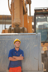 Worker walking by machinery on site