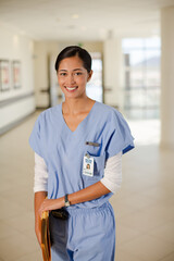 Portrait of smiling nurse in hospital corridor