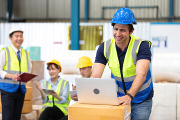 engineer or factory worker using laptop computer and talking to someone