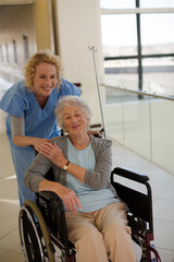 Fototapeta na wymiar Portrait of smiling nurse and elderly patient in wheelchair