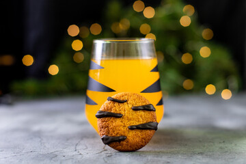 orange mandarin cocktail in glass with black stripes and cookies. Christmas holiday drink. Concept...