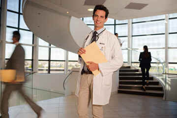 Fototapeta premium Portrait of smiling doctor in hospital atrium
