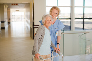 Nurse helping senior patient with walker in hospital corridor