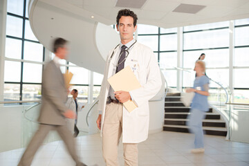 Fototapeta premium Portrait of smiling doctor in hospital atrium