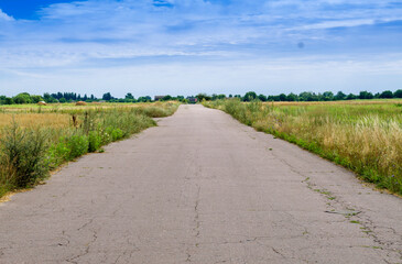 Obraz premium road in the countryside with blue sky on the horizon