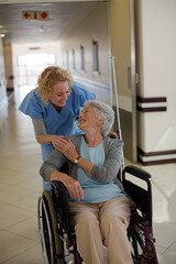 Fototapeta na wymiar Portrait of smiling nurse and elderly patient in wheelchair