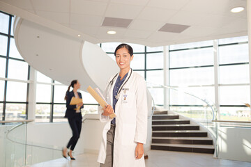 Portrait of smiling doctor in hospital atrium