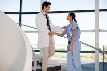 Fototapeta premium Doctor and nurse handshaking on hospital staircase