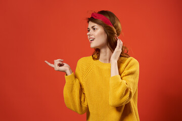Naklejka premium woman in yellow sweater with bandage on her head fashion red background studio