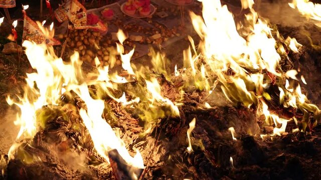 Chinese hungry ghost festival burning flame fire glowing ashes firefly colourful variety prayer paper joss money fake currency joss stick mini fag food fruit offering