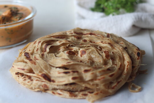 Parotta or Porotta, a layered flatbread made of Maida. This flaky ribbon pancake is a favourite of Kerala. Shot with Butter chicken