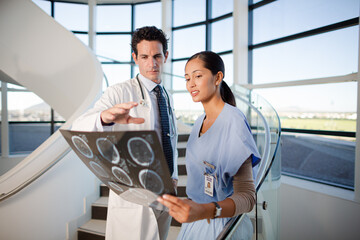 Fototapeta na wymiar Doctor and nurse viewing head x-rays on hospital staircase