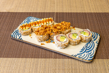 Assorted uramaki platter with sesame seeds and Philadelphia cheese filling with surimi, avocado, fish roe and crispy onion