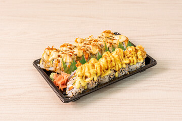 Uramaki dragon roll with prawns in tempura many sauce, crispy onion, wasabi and ginseng