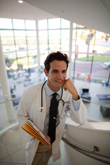 Portrait of smiling doctor on stairs in hospital