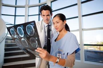 Doctor and nurse viewing head x-rays on hospital staircase