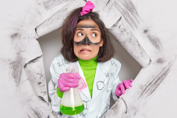 Lab chemist experiments with different substances in order to produce viable products holds...