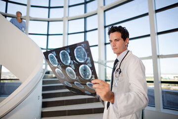 Doctor viewing head x-rays on staircase