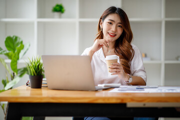 Portrait of smiling beautiful business asian woman with working in modern office desk using computer, Business people employee freelance online marketing e-commerce telemarketing concept.