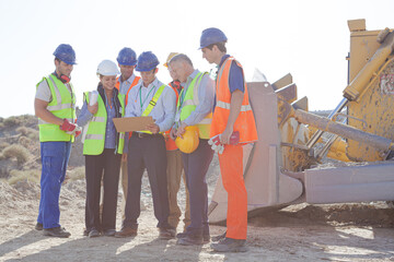Business people and workers talking in quarry