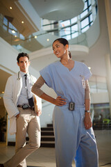 Portrait of smiling doctor and nurse in hospital atrium