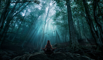 Woman meditating and observing the forest